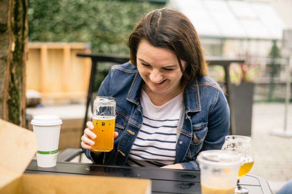 Woman laughing drinking beer outside