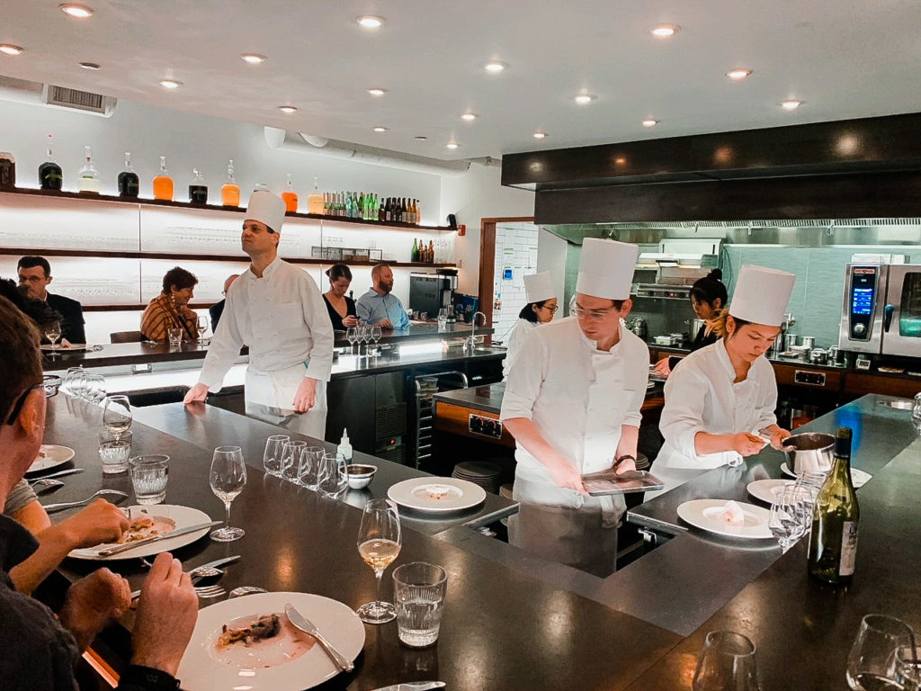 Chefs preparing food for customers at Tasting Counter restaurant