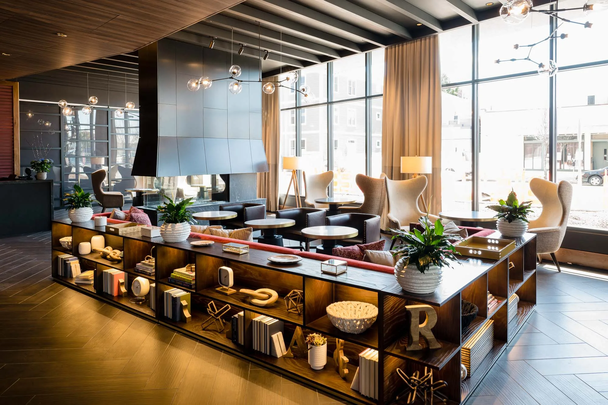 Seating area with lounge chairs and tables at Cambria Hotel in Somerville