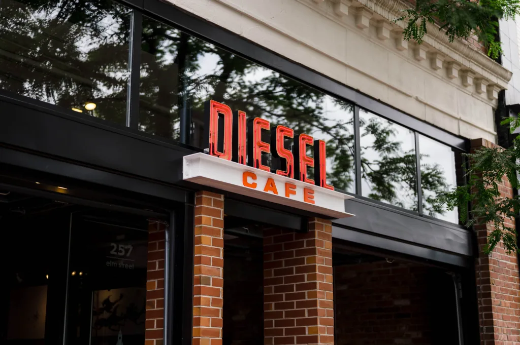 Neon sign over the entryway for Diesel Cafe restaurant in Somerville, MA