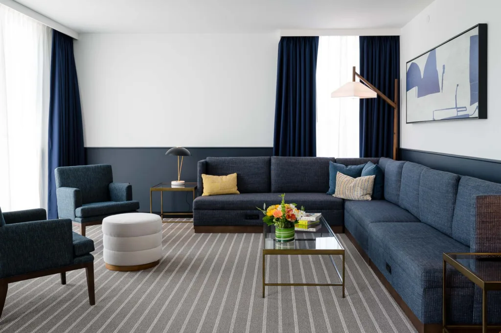 Spacious living area with a sofa and chairs at Cambria Somerville hotel