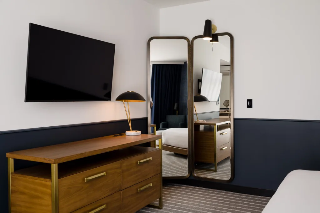 Dresser, TV, and a corner mirror in a room at our hotel near Boston, MA