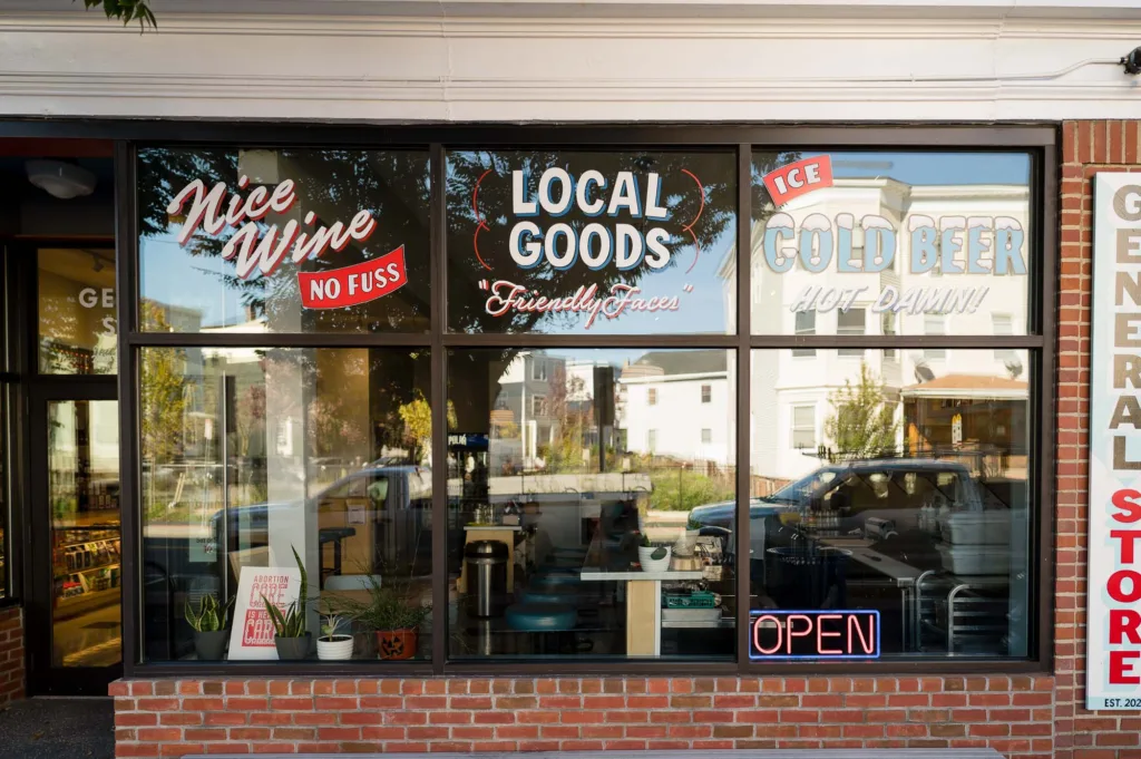 Retro-style writing on the front windows of a general store in Somerville