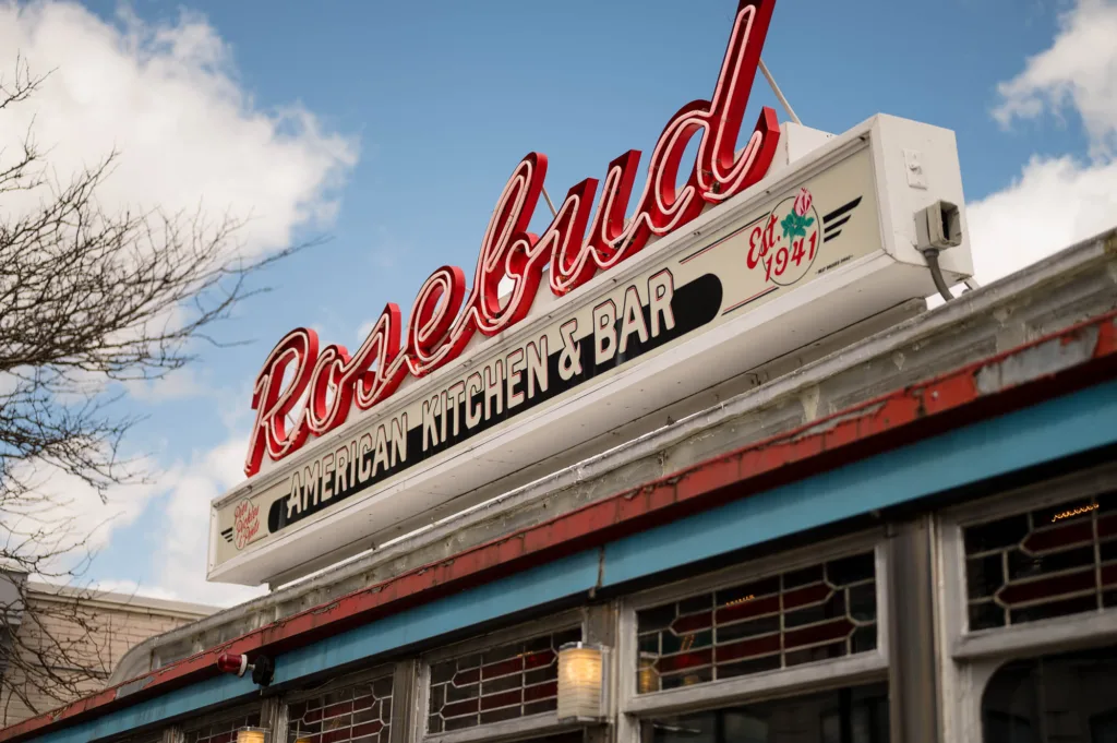 Neon sign over the entryway of Rosebud American Kitchen & Bar
