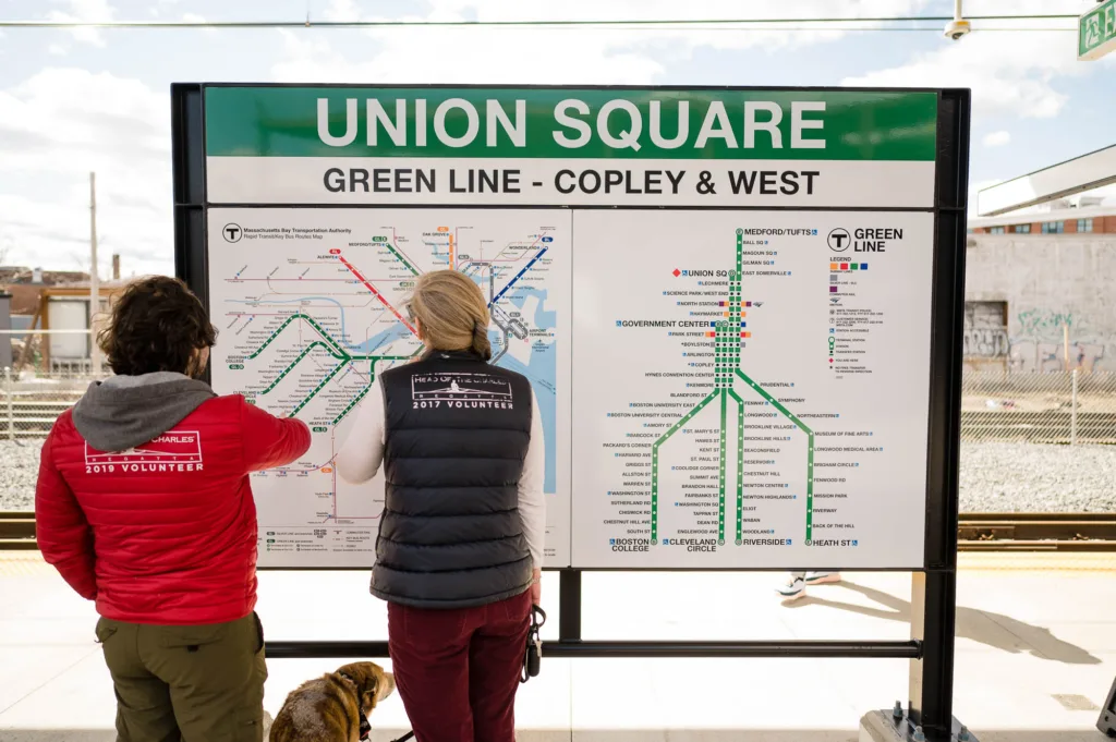 Two people browsing a map of the Green Line in Union Square, MA