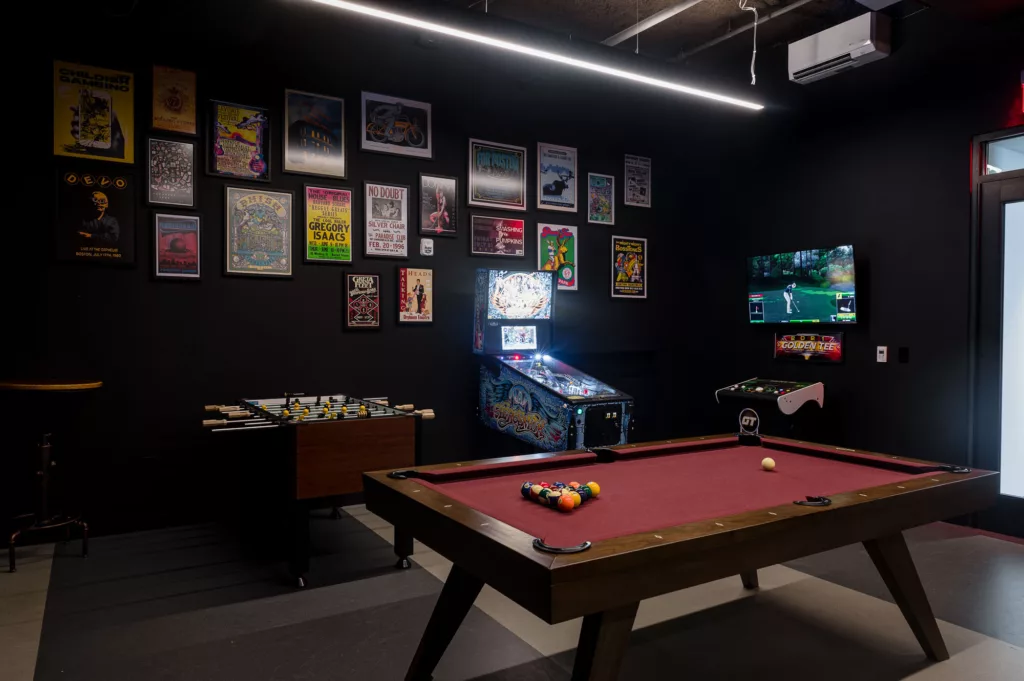 Dark game room with billiards, foosball, pinball, and virtual golf