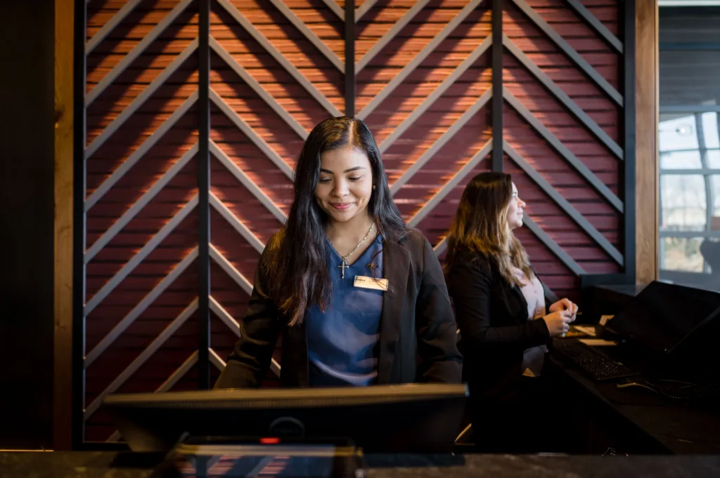 Woman checking in a guest at Cambria hotel in Somerville-Boston