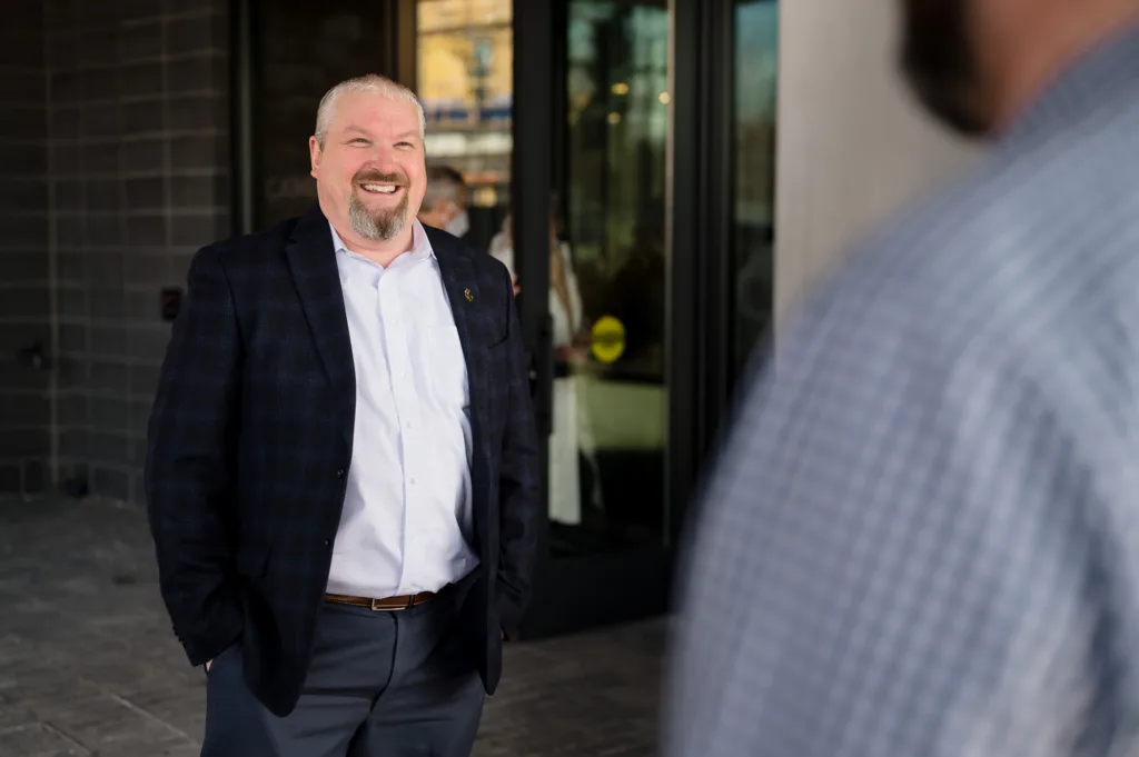 Man in a suit smiling at Cambria hotel in Somerville-Boston