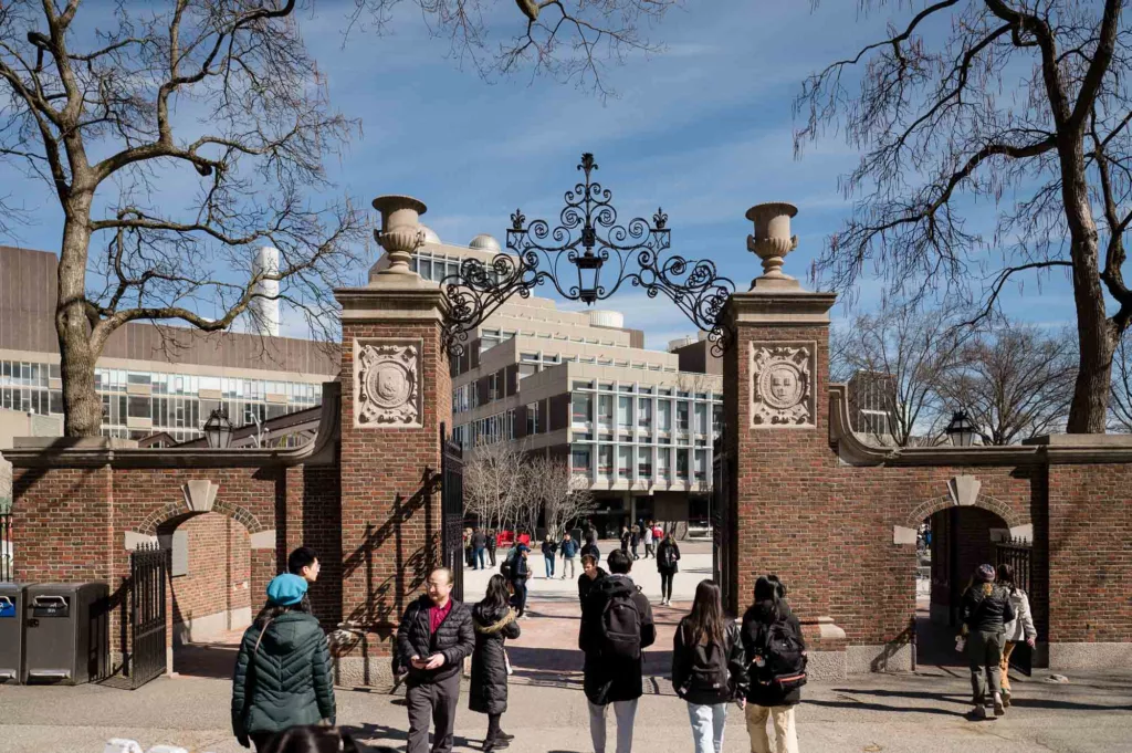 People strolling through a gate at Harvard University