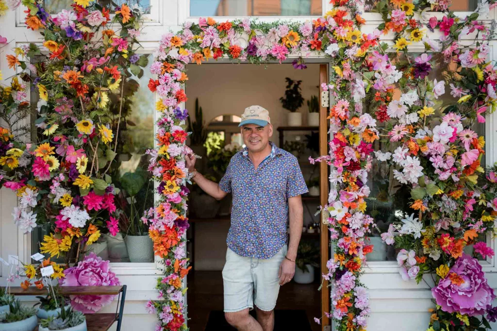 Man standing in a floral doorway at Wagner Floral Designs in Somerville