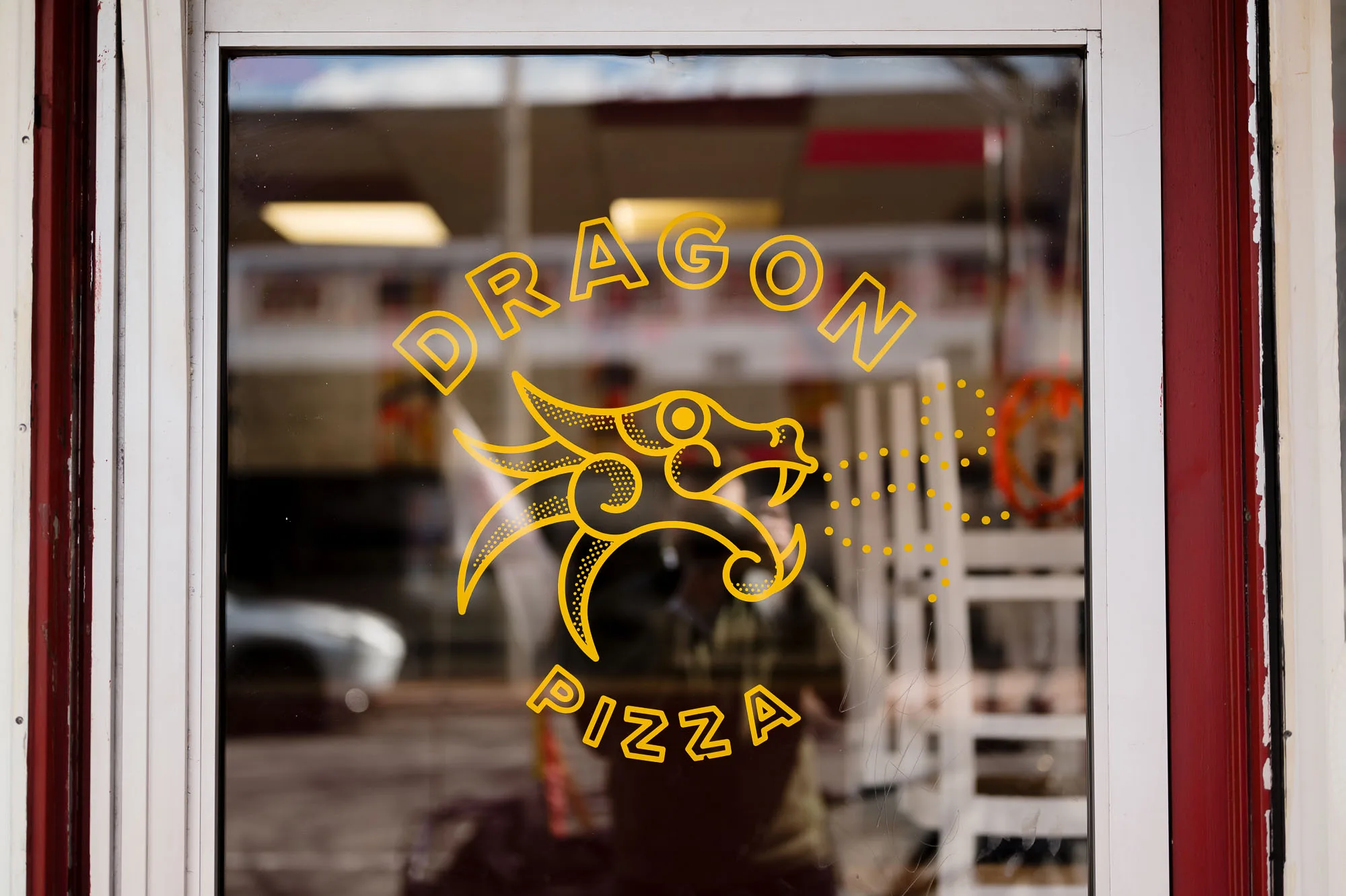 Dragon Pizza logo on a storefront window