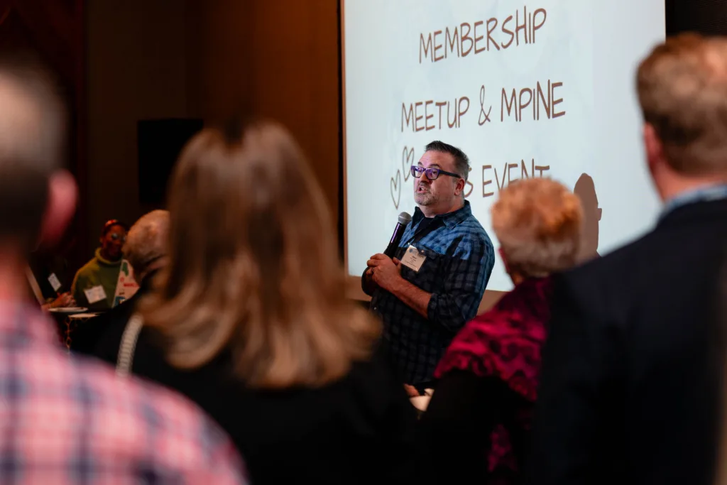 Speaker presenting to an audience in a meeting space at Cambria Hotel Boston-Somerville