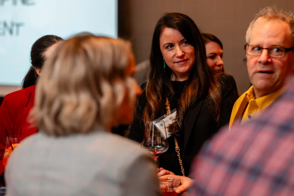 Guests mingling with drinks at an event at Cambria Hotel Boston-Somerville