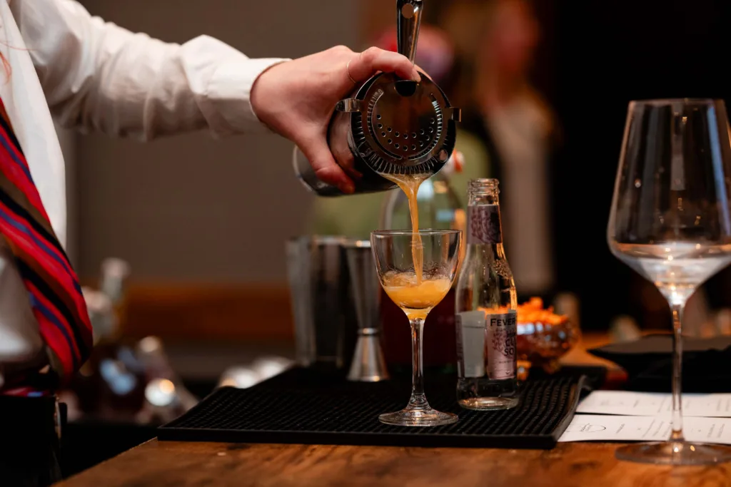 Bartender pouring a cocktail at Cambria Hotel Boston-Somerville
