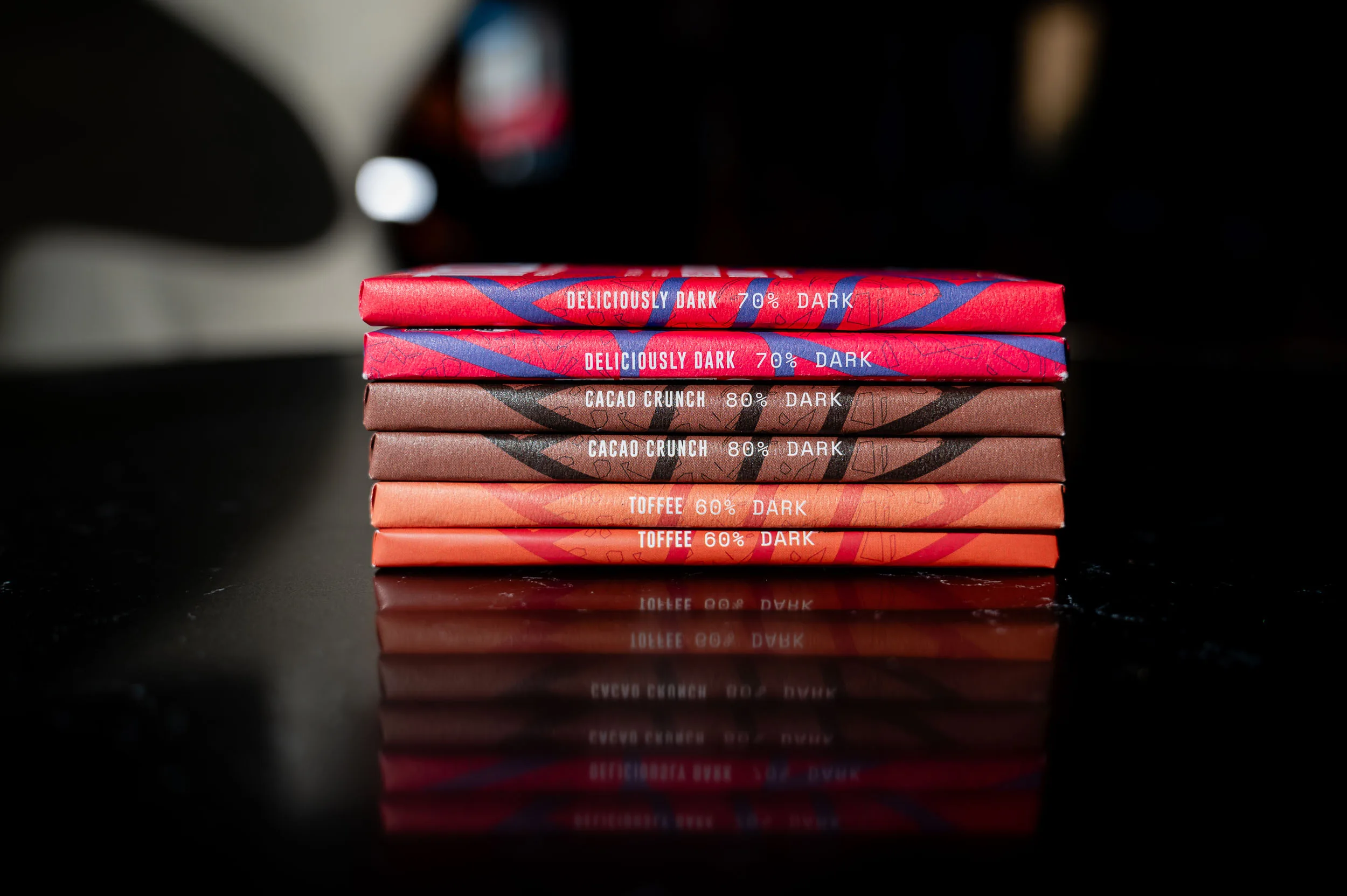 stack of wrapped chocolate bars on a dark surface