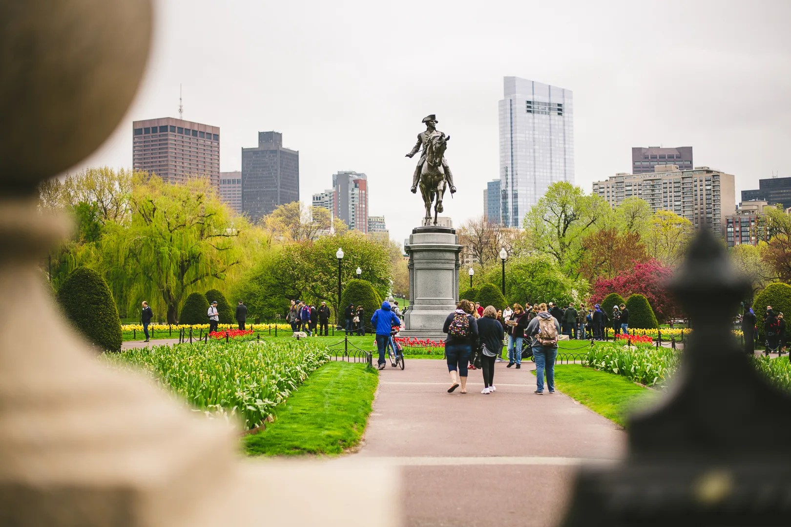 public garden with equestrian statue and city skyline in the background